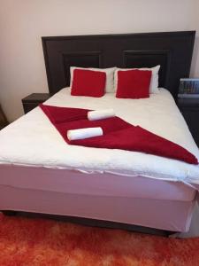 a bed with red and white blankets on it at Pleasant Field Bed And Breakfast in Gaborone +10 photos