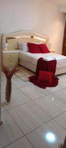 a bedroom with a bed with red pillows on the floor at Pleasant Field Bed And Breakfast in Gaborone