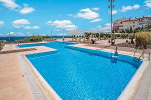 a large swimming pool with blue water at Holiday World Casamaïa Apartments, Affiliated by Meliá in Benalmádena