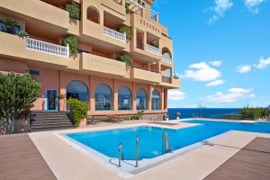 a hotel with a swimming pool in front of a building at Holiday World Casamaïa Apartments, Affiliated by Meliá in Benalmádena