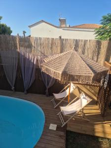 a patio with two chairs and an umbrella and a pool at Grand Villa Nefeli - Private Spa in Lagonissi +49 photos