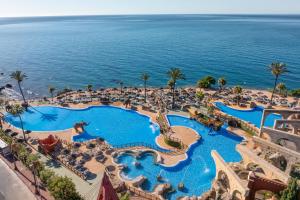 an aerial view of a resort pool with the ocean in the background at Holiday World Casamaïa Apartments, Affiliated by Meliá in Benalmádena