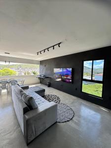 a living room with a couch and a tv at Arcoverde - Varanda com Vista Panorâmica - excelente localização - até 6 pessoas in Arcoverde
