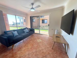 a living room with a couch and a tv at Pacific Court 2 in South West Rocks