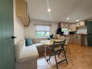 a living room with a couch and a table at Mobile Home WT 1906 in Saint-Pierre-dʼOléron +3 photos