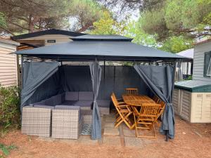 a gazebo with a table and chairs under it at Mobile Home WT 1906 in Saint-Pierre-dʼOléron