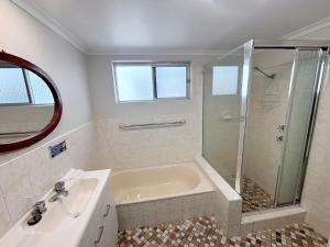 a white bathroom with a shower and a sink at Pacific Court 2 in South West Rocks +8 photos