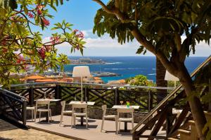 a table and chairs on a balcony overlooking the ocean at Meliá Jardines del Teide - Adults Only in Adeje