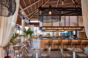 a restaurant with tables and chairs and a bar at Meliá Jardines del Teide - Adults Only in Adeje