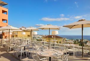 a group of tables and chairs with umbrellas at Meliá Jardines del Teide - Adults Only in Adeje