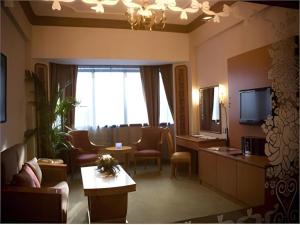 a hotel room with a waiting area with a television at The CentrePoint Hotel in Kampong Kiulap
