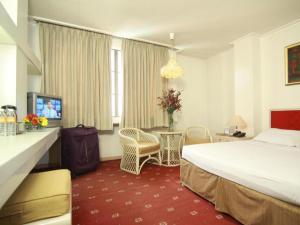 a hotel room with a bed and a table and chairs at Hotel Supreme in Baguio