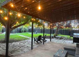 a pavilion with lights and a table and a tree at Private lux lower level flat fully fenced in Twin Falls