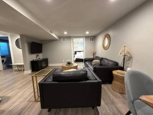 a living room with two black couches and a television at Private lux lower level flat fully fenced in Twin Falls