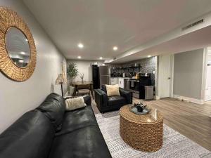 a living room with a black leather couch and a table at Private lux lower level flat fully fenced in Twin Falls