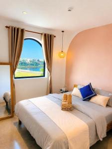 a bedroom with a large bed with a large window at La Riva Riverside Hue Hotel & Rooftop in Hue +4 photos