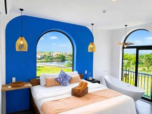 a bedroom with a large bed with a tub and a window at La Riva Riverside Hue Hotel & Rooftop in Hue