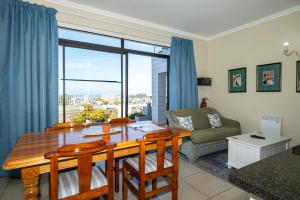 a living room with a wooden table and a couch at The Lookout Guest House in Port Alfred