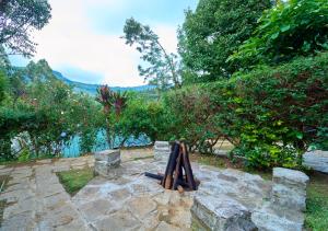a statue in a garden with a river in the background at Ministers Mansion Kanthalloor Pool Resort by VOYE HOMES in Kanthalloor