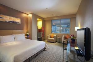 a hotel room with a bed and a flat screen tv at Catic Hotel--Adjacent Buliding in Zhuhai