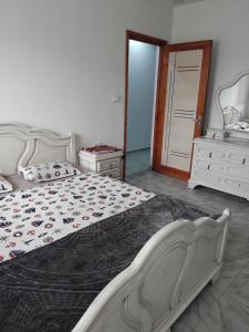 a bedroom with a bed and a dresser at Appartement S1 Tulipe in Zarzis