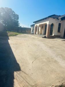 an empty dirt road in front of a building at Alwaba guest house in Mthatha