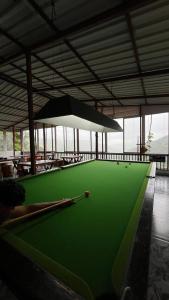 a green pool table in a building with a ceiling at Kalasita in Mahabaleshwar