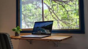 a laptop computer sitting on a wooden table next to a window at Guadalia Living Smr in Santa Marta