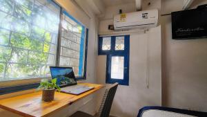 a laptop computer sitting on a wooden desk in a room at Guadalia Living Smr in Santa Marta