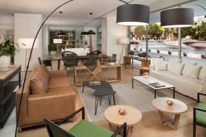 a living room with a couch and tables at Meliá Lebreros in Seville