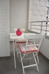 une table blanche avec un vase rouge et une chaise dans l'établissement 4B @ Longchamp, à Ostende