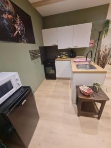 a kitchen with a microwave and a table in it at Tiny House - Studio in Eygurande-et-Gardedeuil