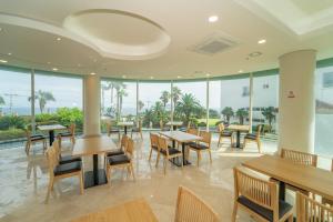 a restaurant with tables and chairs and windows at Seaore Resort in Seogwipo
