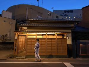 a woman walking in front of a garage at Cove琴平 - 1組貸切 最大8名 こんぴらさん徒歩すぐ in Kotohira
