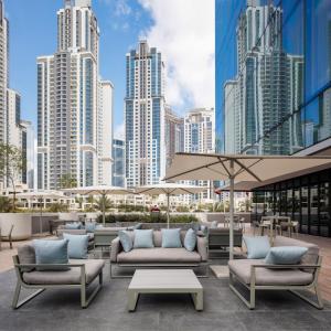 a patio with couches and tables in front of a city at ME by Meliá Dubai in Dubai