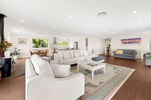 a living room with white furniture and a table at Olive Grove - Pet Friendly with Fireplace in Bellawongarah