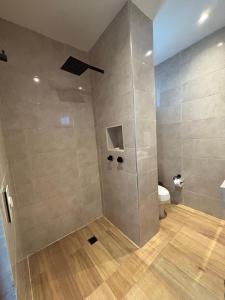 a bathroom with a shower with a toilet in it at Ocean Inn- Sector el Bluff in Bottom House