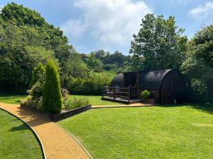 a yurt in a garden with a bench and trees at Idris Pod in Tremeirchion