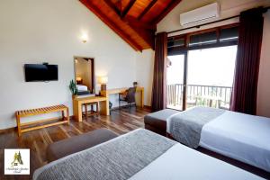 a hotel room with two beds and a television at Marabedda Gardens Resort in Rikillagaskada +67 photos