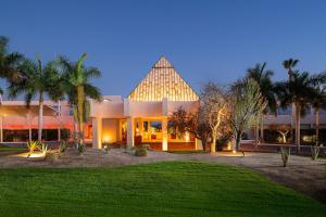 a large building with a pointed roof with palm trees at Paradisus by Meliá Los Cabos - Adults Only - All Inclusive in San José del Cabo