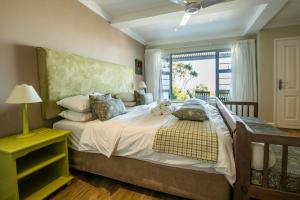a bedroom with a large bed with a window at The Lookout Guest House in Port Alfred +120 photos