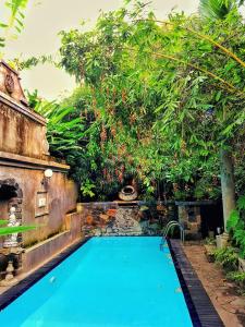 an outdoor swimming pool in a garden with trees at Boutique Villa with a Pool in Kandy +39 photos