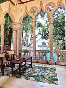 a patio with a table and chairs and columns at Boutique Villa with a Pool in Kandy