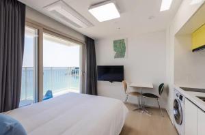 a bedroom with a large bed and a table with chairs at 양양 죽도해변호텔 오션뷰스테이 일출뷰 바다뷰 힐링뷰 낭만뷰 넷플릭스완 in Saetchak