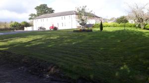 a large grassy yard with a large white building at The Pilgrims Rest Hotel (Adults Only) in Lismore