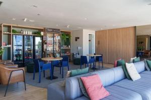 a living room with a blue couch and tables and chairs at Skylux by Tegra in Rio de Janeiro