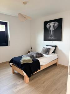 a bedroom with a bed with a picture of an elephant at Ten Zilte in Blankenberge