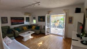 a living room with a couch and a sliding glass door at Apart SRDJ&MAR in Dobra Voda