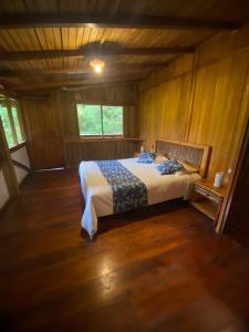 a bedroom with a bed in a wooden room at Hotel El Abrazo del Arbol in Mindo