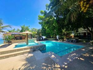a swimming pool in front of a house at FFG Eden Private Resort in Basdiot